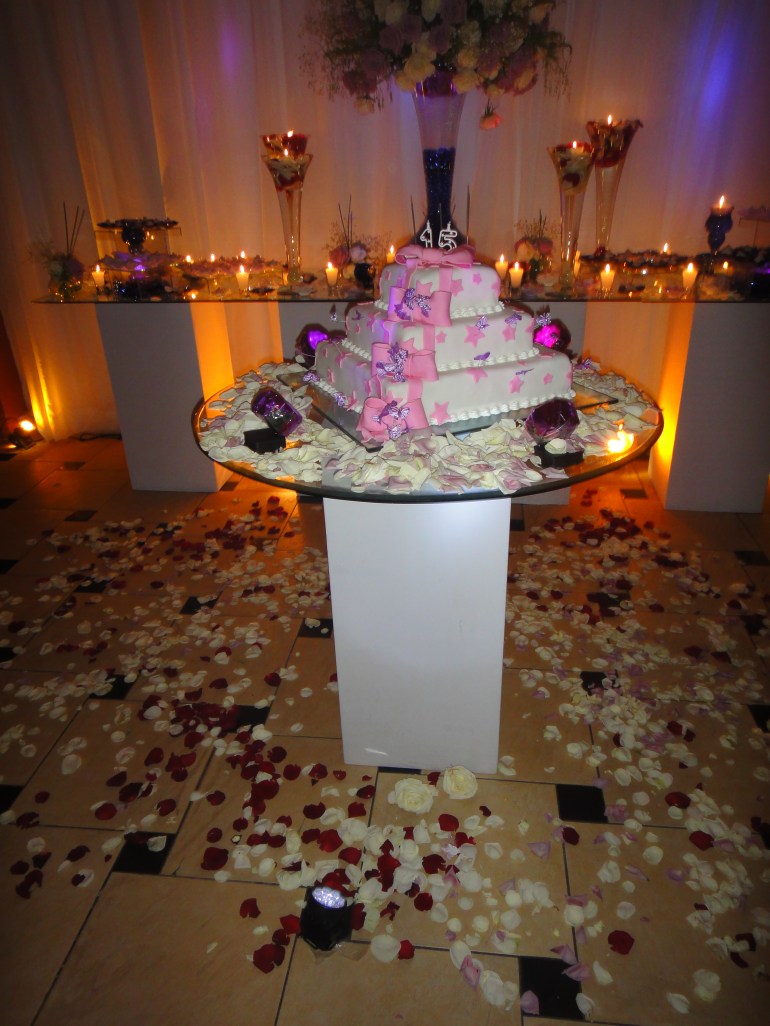 Mesa do bolo. Pétalas jogadas no chão. O efeito ficou bem bonito.